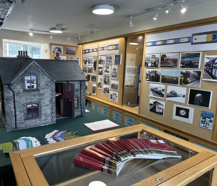 Replica of a station master's house in exhibition space with photographs.