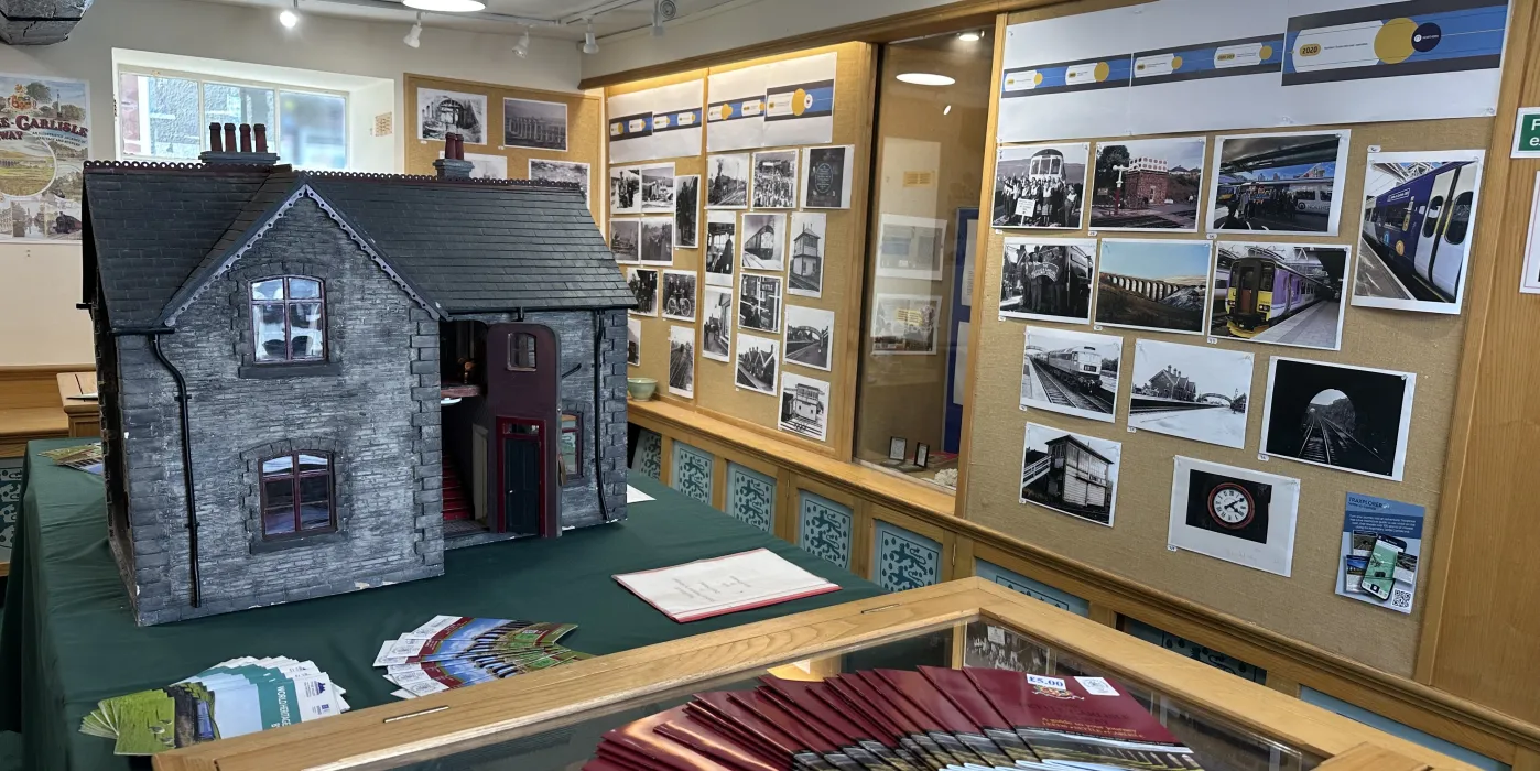 Replica of a station master's house in exhibition space with photographs.